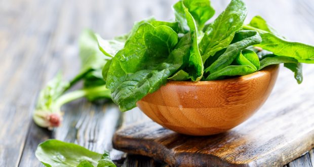 wooden bowl overflowing with fresh spinach