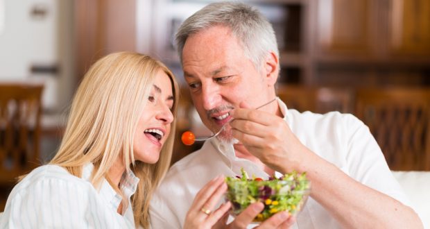 man and woman share a salad