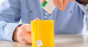 Man putting artificial sweetener in his tea