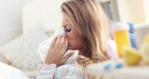 woman sneezing into tissue