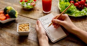 writing down diet plan in a notebook