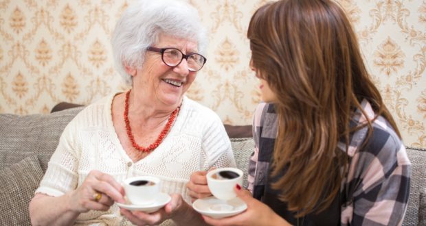 Senior woman drinking coffee with grand-daughter