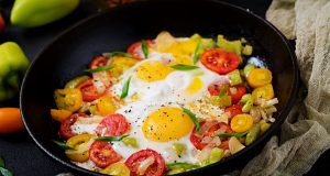 Fried eggs and veggies in cast iron skillet