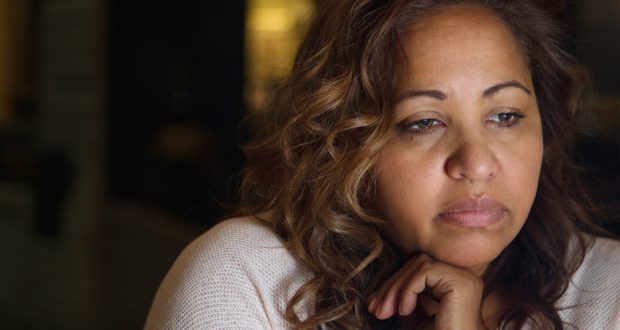 woman sitting alone looking unhappy