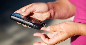 Woman pricking finger to measure blood sugar