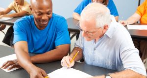 older man writing with pencil and paper