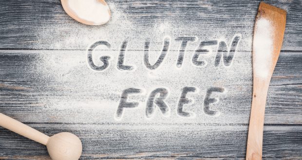 The words gluten free written in flour on wooden table