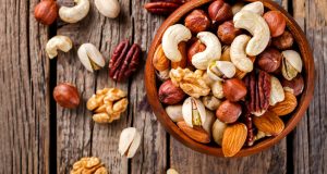 Mixed nuts in bowl on wooden table