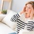 woman with headache sitting on couch